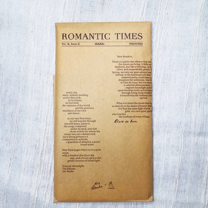 A vintage-style kraft booklet titled 'ROMANTIC TIMES' with columns of text, photographed flat on a light gray textured surface.
